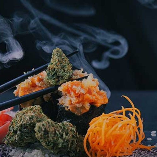 A Person Holding A Medical Cannabis Bud With Chopsticks Over A Plate Of Sushi Like Buds and Ginger - Edibles
